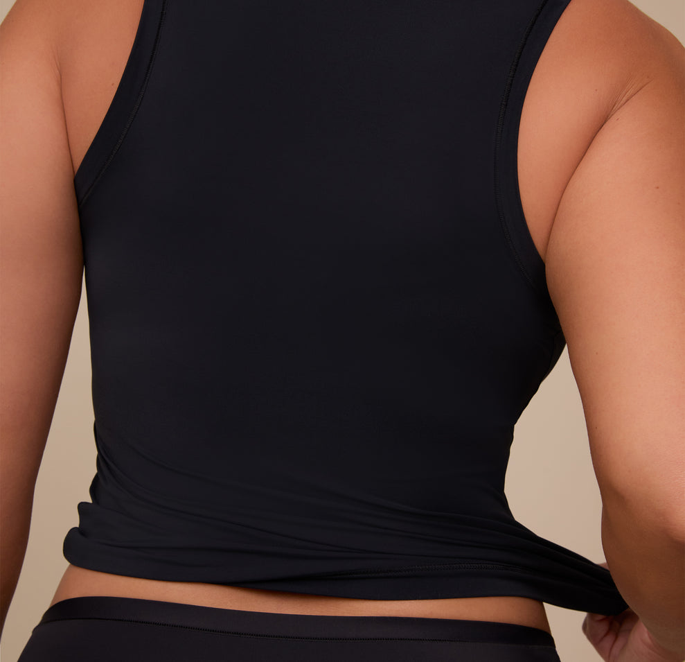 Detail view of the back of the Bliss Tank in Black on Sonnie, showing the tank’s smooth texture and minimal seam design.