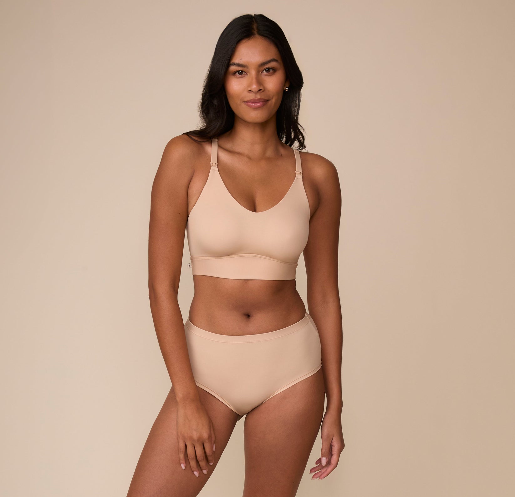 Victoria wears the Bliss Nursing Bralette in Beige paired with the matching Bliss Highwaist Brief. The set creates a sleek, coordinated look with a focus on all-day comfort.