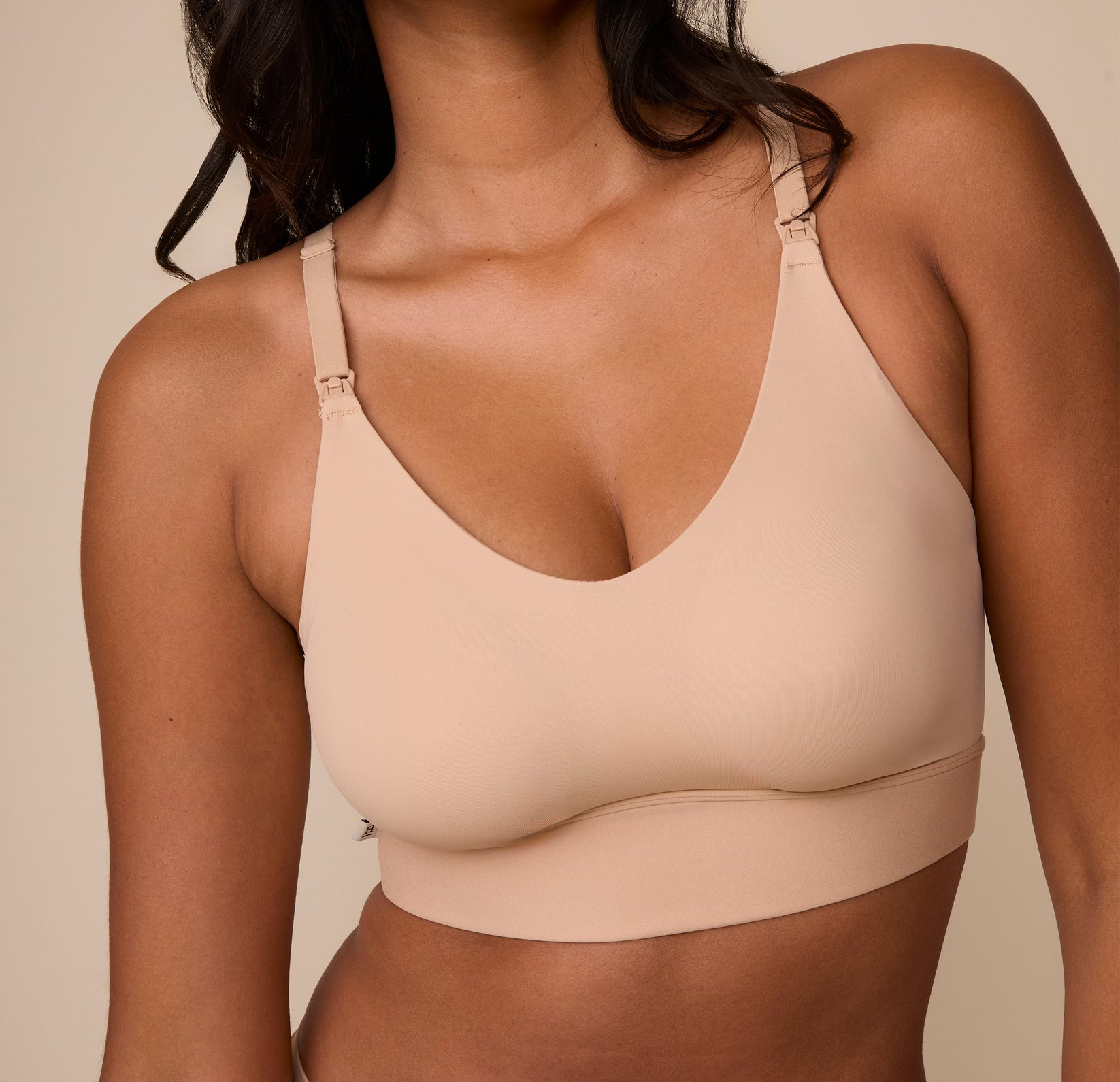 A cropped, detailed shot of Victoria wearing the Bliss Nursing Bralette in Beige, highlighting the smooth, molded cups and nursing clips on the straps.