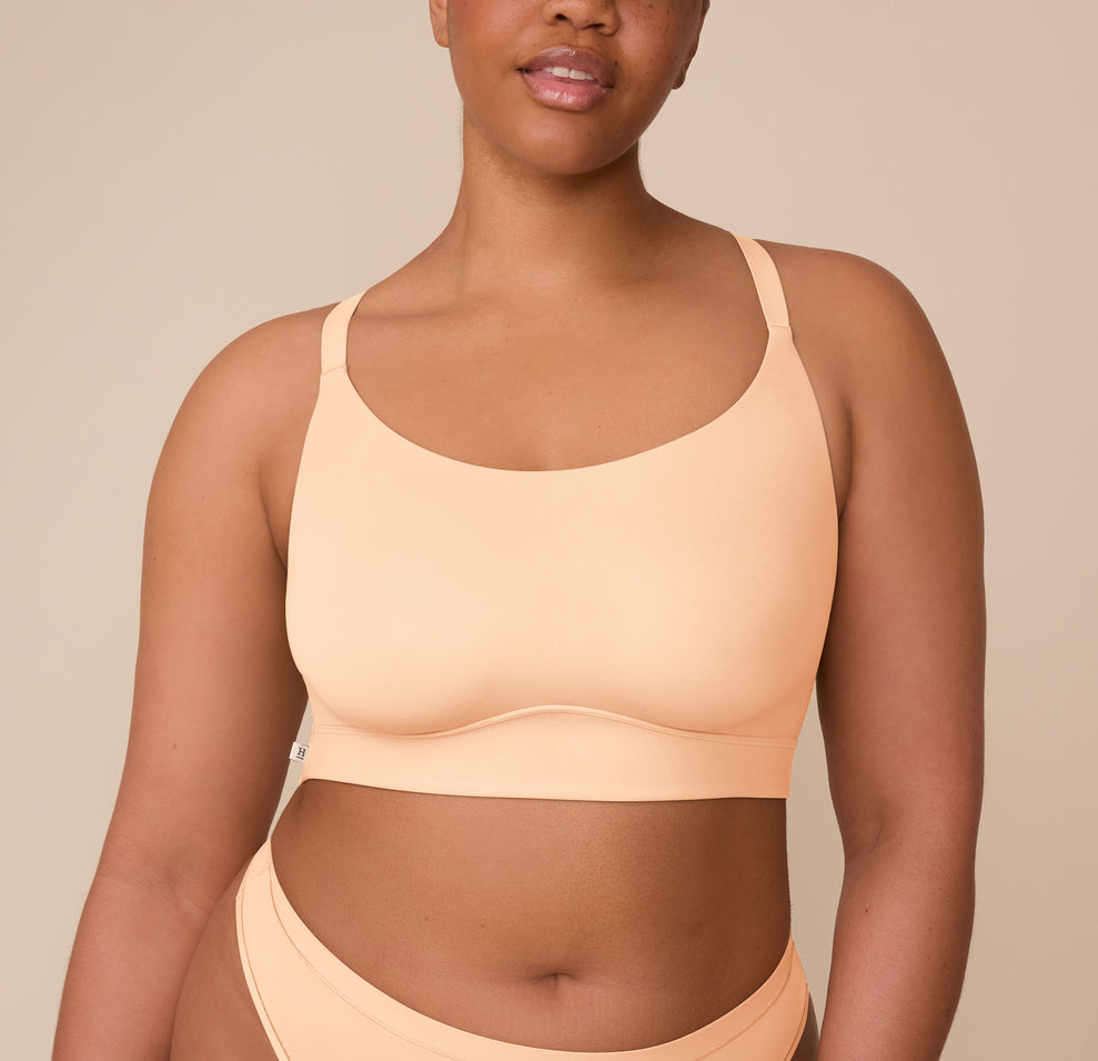 Front view of Zarria wearing the Bliss Racerback Bralette in Daybreak. The image highlights the smooth scoop neckline and soft, molded cups for wire-free support. sizing: Zarria wears size XL