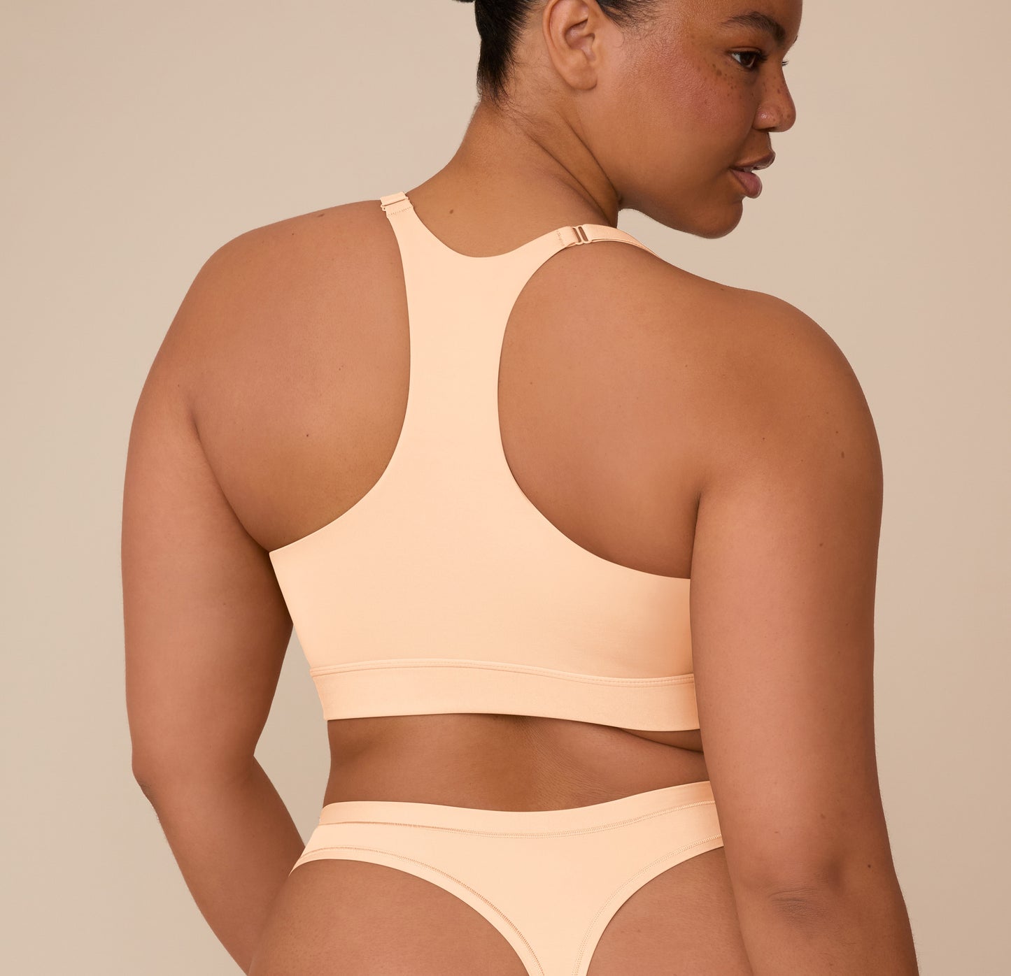 Back view of Zarria in the Bliss Racerback Bralette in Daybreak, showing the full racerback silhouette and adjustable straps.
