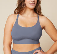 Summerlyn standing with her hand on her hip, wearing the Bliss Racerback Bralette in Steel and the Bliss Boyshort in Steel. The front view highlights the supportive fit of the bralette and the comfortable coverage of the boyshort. sizing: Summerlyn wears size Large