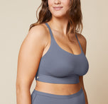 Summerlyn standing with her arms relaxed by her sides, wearing the Bliss Racerback Bralette in Steel and the Bliss Boyshort in Steel. The image shows the front view of the set, emphasizing the soft fabric and fit.