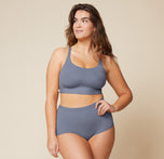 Summerlyn standing confidently with her hand on her hip, wearing the Bliss Racerback Bralette in Steel and the Bliss Boyshort in Steel. This front view showcases the full outfit, emphasizing the supportive design of both pieces.