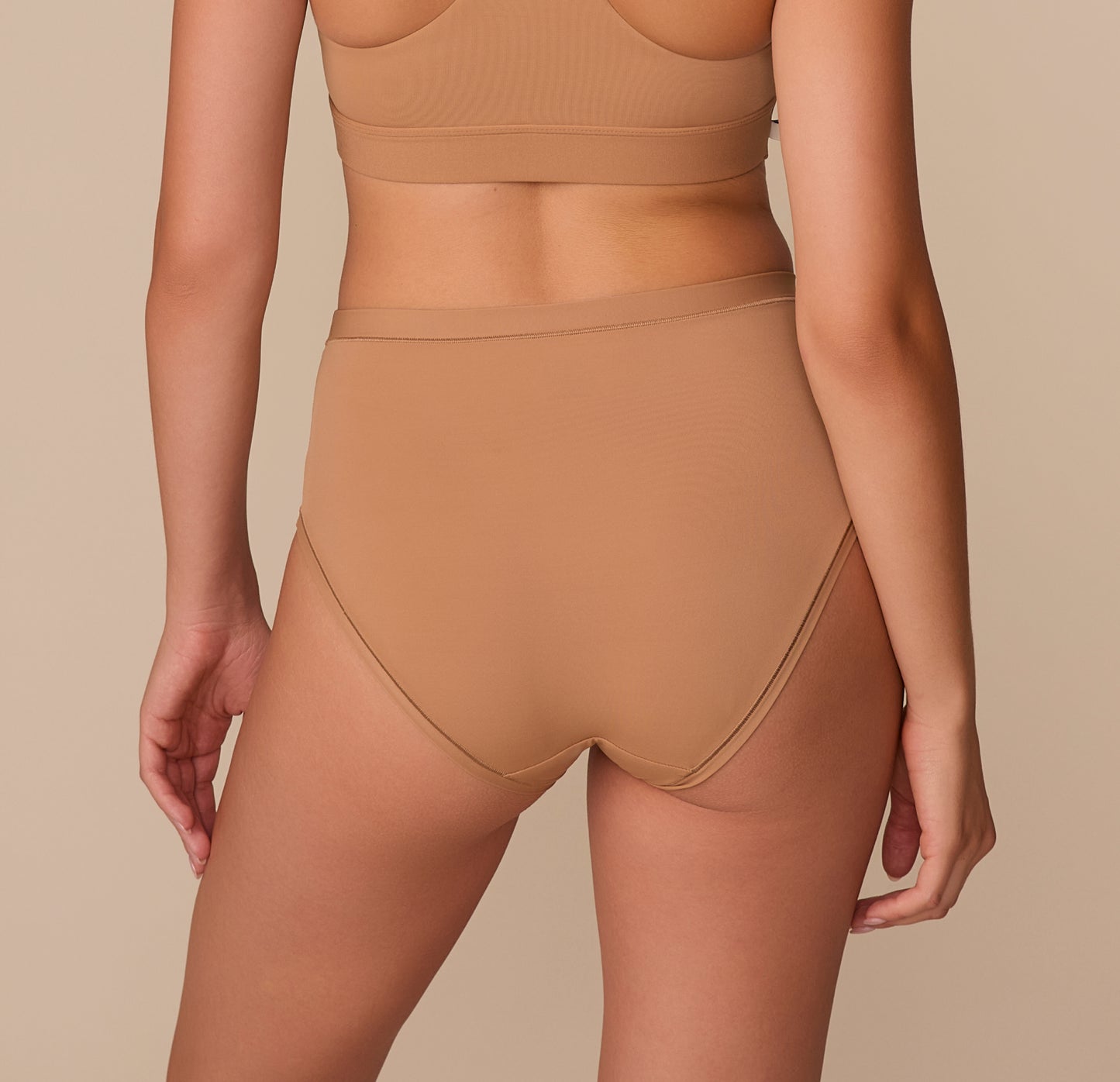 Rear view of the Bliss Highwaist Brief in Tan, highlighting full coverage and a sleek, no-dig waistband.