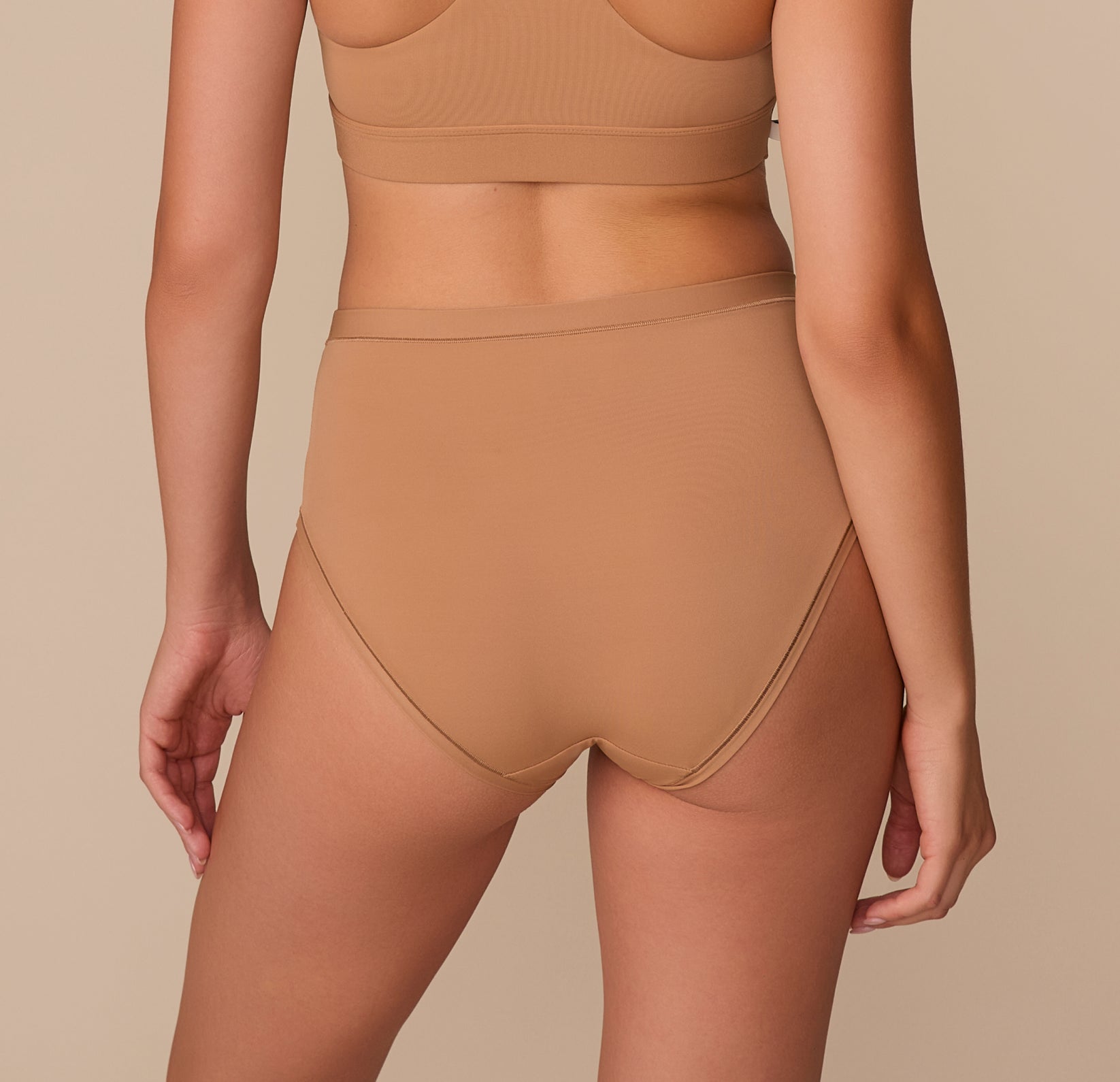 Rear view of the Bliss Highwaist Brief in Tan, highlighting full coverage and a sleek, no-dig waistband.