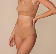 Side angle of the Bliss Highwaist Brief in Tan, displaying the soft stretch fabric and flattering leg line.