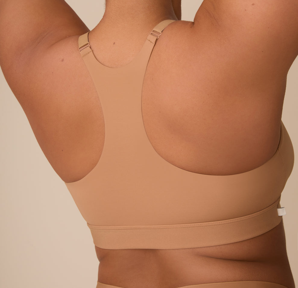 Close up back view of Zarria in the Bliss Racerback Bralette in Tan. The microfiber material lays smoothly against her back for a comfortable look.