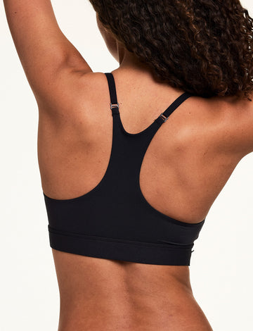 Back view of Courtney wearing the Bliss Racerback Bralette in Black, featuring adjustable straps and a racerback silhouette with a smooth finish.