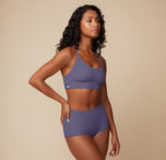Ally is shown at a slight angle, wearing the Bliss Racerback Bralette in Overcast. The racerback style and adjustable straps ensure a secure and functional fit.