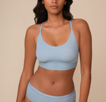 Close-up of Victoria wearing the Bliss Racerback Bralette in Glacier. The bralette features a scoop neckline, smooth wireless cups, and a wide underband for added support. sizing: Victoria wears size Medium