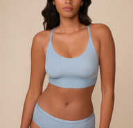 Close-up of Victoria wearing the Bliss Racerback Bralette in Glacier. The bralette features a scoop neckline, smooth wireless cups, and a wide underband for added support. sizing: Victoria wears size Medium