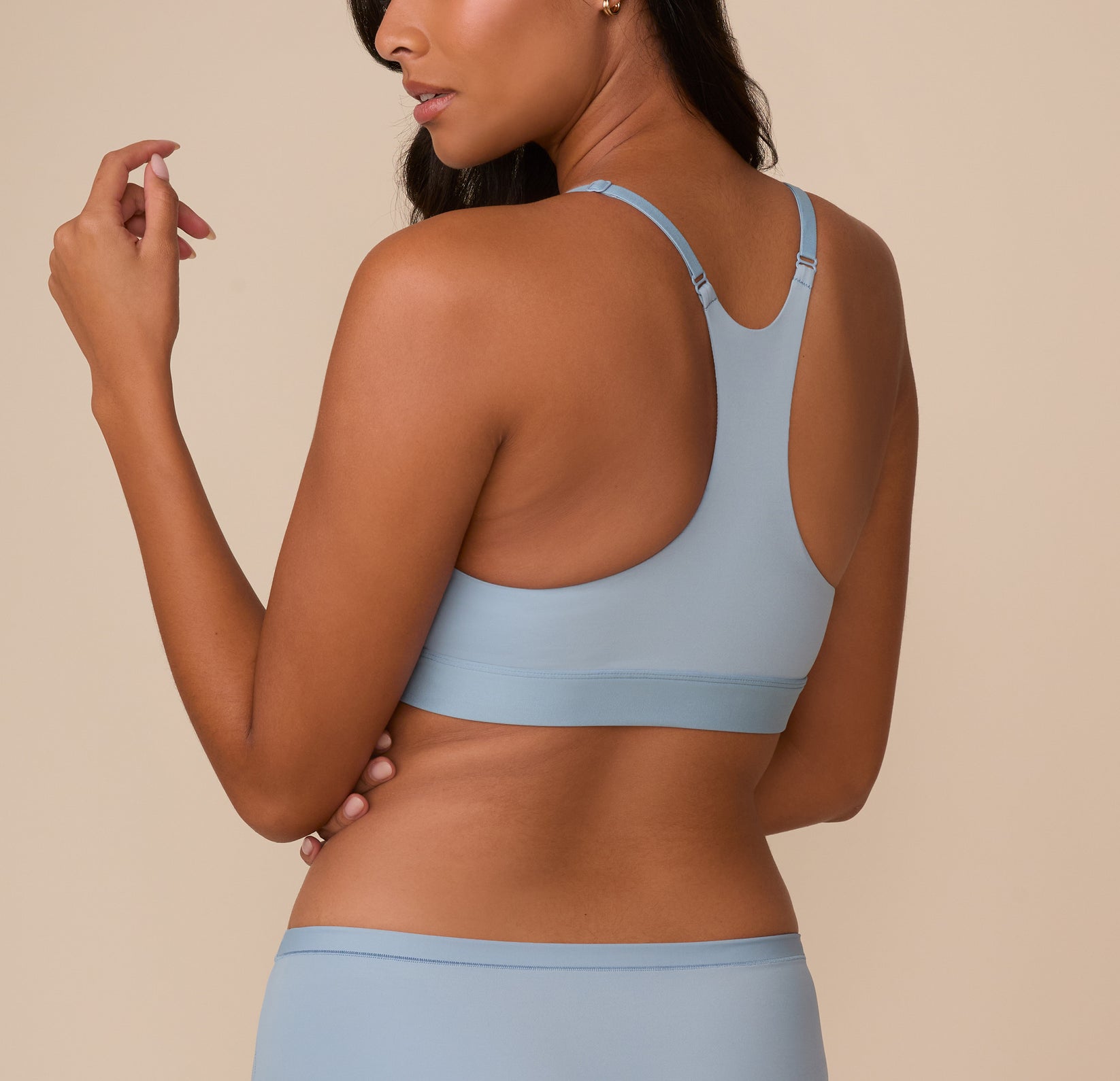 Rear view of Victoria in the Bliss Racerback Bralette in Glacier, showcasing the scoop back and front adjustable racerback straps designed for comfort and flexibility.