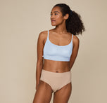 Zoe standing with hands resting at her sides, wearing the Bliss Scoop Bralette in Tidal and the Bliss Highwaist Brief in Beige. She faces forward, smiling softly, showcasing the comfortable fit of both pieces.