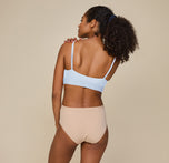 Back view of Zoe standing upright, hands resting casually at her sides, in the Bliss Scoop Bralette and Bliss Highwaist Brief, highlighting the full coverage and soft back design.