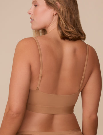 Back view of Sonnie in the Bliss Scoop Bralette in Tan, highlighting the streamlined design and barely-there back coverage.