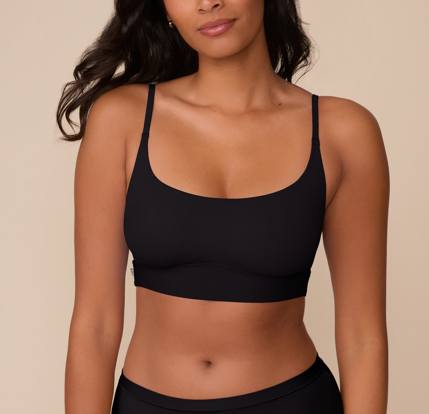 Close-up of Victoria wearing the Bliss Scoop Bralette in Black, highlighting the scoop neckline and minimal seam silhouette. sizing: Victoria wears size Medium