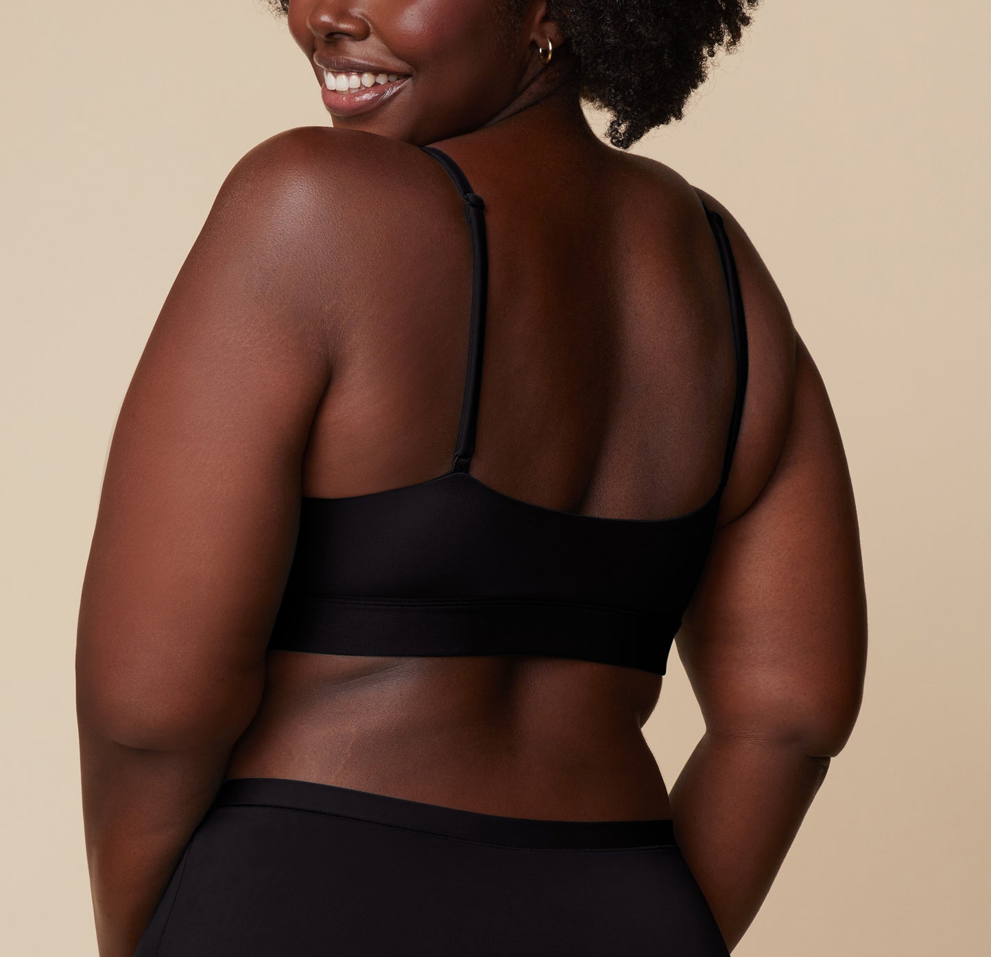 Rear view of Akesha in the Bliss Scoop Bralette in Black, showing the full back band and adjustable straps.
