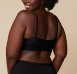 Rear view of Akesha in the Bliss Scoop Bralette in Black, showing the full back band and adjustable straps.