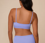 Rear view of Victoria showcasing the back of the Bliss Scoop Bralette in Dusk. The scoop back and slim adjustable straps offer a supportive yet minimal look.