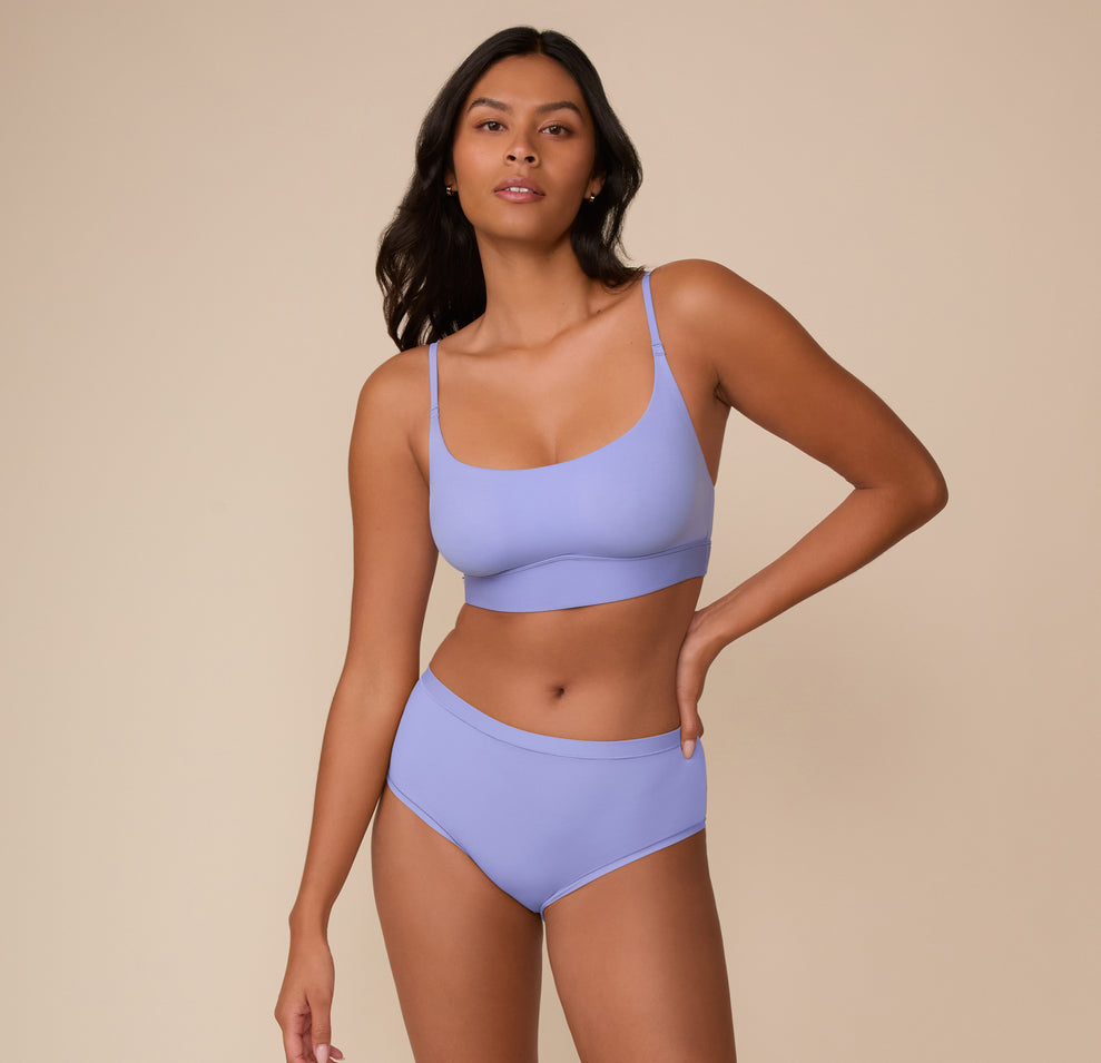 Full front view of Victoria wearing the Bliss Scoop Bralette and the matching Bliss Highwaist Brief in Dusk. The image highlights the bralette’s clean lines and body-hugging design.