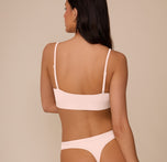 Back view of Marcela in the Bliss Scoop Bralette in Rose, highlighting the minimalist design and flexible fit of the back band.