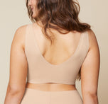 The back view of Summerlyn wearing the Bliss Sleek Lined Bralette and No-Show Highwaist Brief in Beige highlights the seamless, wireless design for a smooth, comfortable fit.