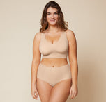 Summerlyn, wearing the Bliss Sleek Lined Bralette and No-Show Highwaist Brief in Beige, displays the bralette's wireless lift and smoothing fabric for a sleek, supportive look.