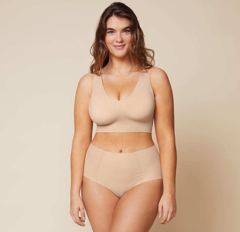 Summerlyn, wearing the Bliss Sleek Lined Bralette and No-Show Highwaist Brief in Beige, displays the bralette's wireless lift and smoothing fabric for a sleek, supportive look.