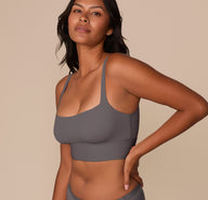 Side angle of Victoria modeling the Bliss Square Neck Bralette in Smoke, emphasizing the sleek lines and flexible, supportive structure.