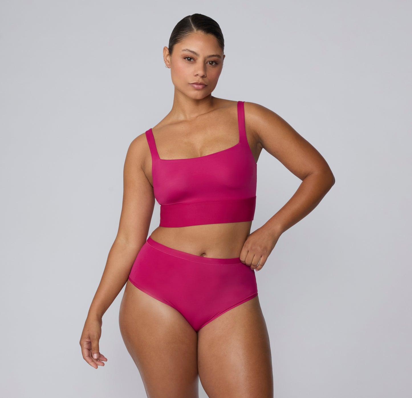 Full-body view on a white studio backdrop of a model wearing the Bliss Square Neck Bralette and matching underwear in Winterberry, showing the coordinated set and streamlined design.