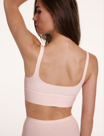 In a studio back view, Gianna wears the Bliss Square Neck Bralette in Champagne Fizz with the Bliss Highwaist Brief in Champagne Fizz, showing the scoop back design, wide band, and soft microfiber fabric with a subtle dotted pattern.