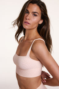 In a studio side view, Gianna wears the Bliss Square Neck Bralette in Champagne Fizz, showing the square neckline, wide wireless band, and soft microfiber fabric with a subtle dotted pattern.