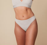 Megan wearing the Bliss Triangle Bralette and Bliss Thong in Frost. The image shows a front view of the thong’s soft microfiber fabric and elastic-free design that lays flat against the skin for a second-skin feel. sizing: Megan wears size Medium