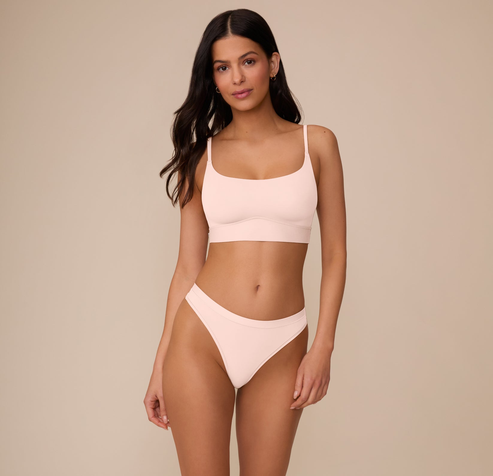 Full front view of Marcela wearing the Bliss Thong and Bliss Scoop Bralette, both in Rose. The set highlights the soft, lightweight microfiber fabric and minimal, everyday design.