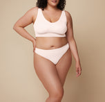Bianca turns at a slight angle, showcasing the Bliss Thong in Quartz and emphasizing its comfortable design and lightweight fit. She wears the coordinating Bliss Bralette. 