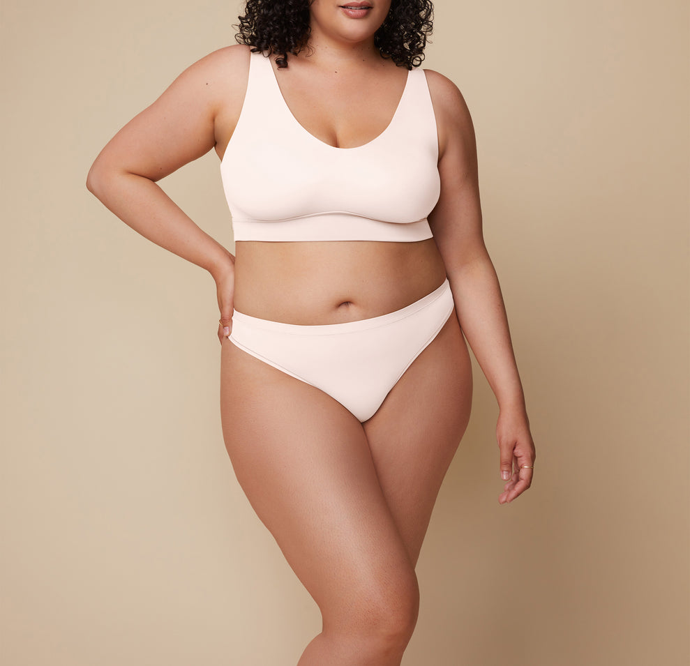 Bianca turns at a slight angle, showcasing the Bliss Thong in Quartz and emphasizing its comfortable design and lightweight fit. She wears the coordinating Bliss Bralette. 
