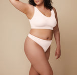Bianca turns at a slight angle, showcasing the Bliss Thong in Quartz. The microfiber material of the thong is emphasized. She wears the coordinating Bliss Bralette. sizing: Bianca wears size XL