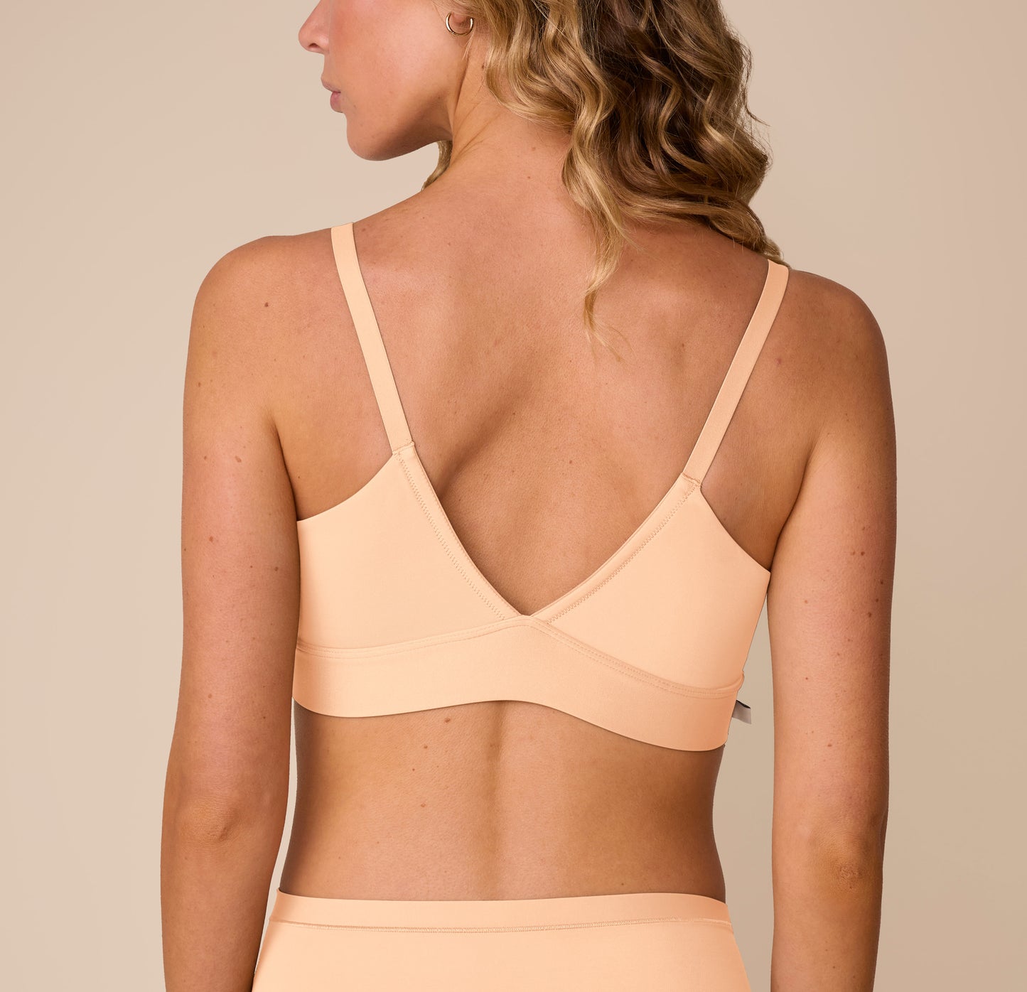 Back view of Freya in the Bliss Triangle Bralette in Daybreak, showcasing the low V back and wide, supportive band.