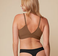 Back view of Megan in the Bliss Triangle Bralette in Brown and Bliss Highwaist Thong in Black. The image highlights the deep V-back of the bralette and the thong’s minimal rear coverage, both designed for smooth lines under clothing.