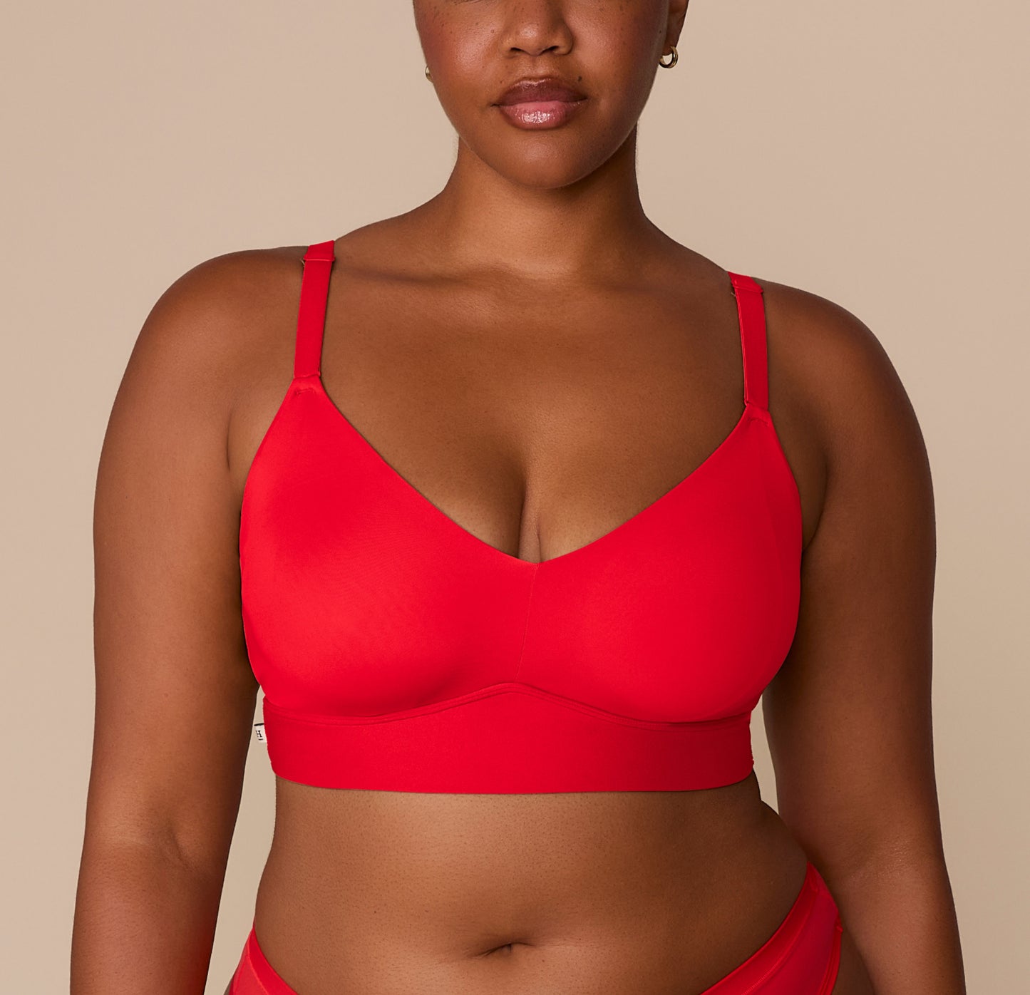 Close-up of Zarria wearing the Bliss Triangle Bralette in Cherry. The image highlights the deep V neckline and ultra-soft microfiber fabric that offers breathable, wireless lift and a barely-there feel. sizing: Zarria wears size 2XL