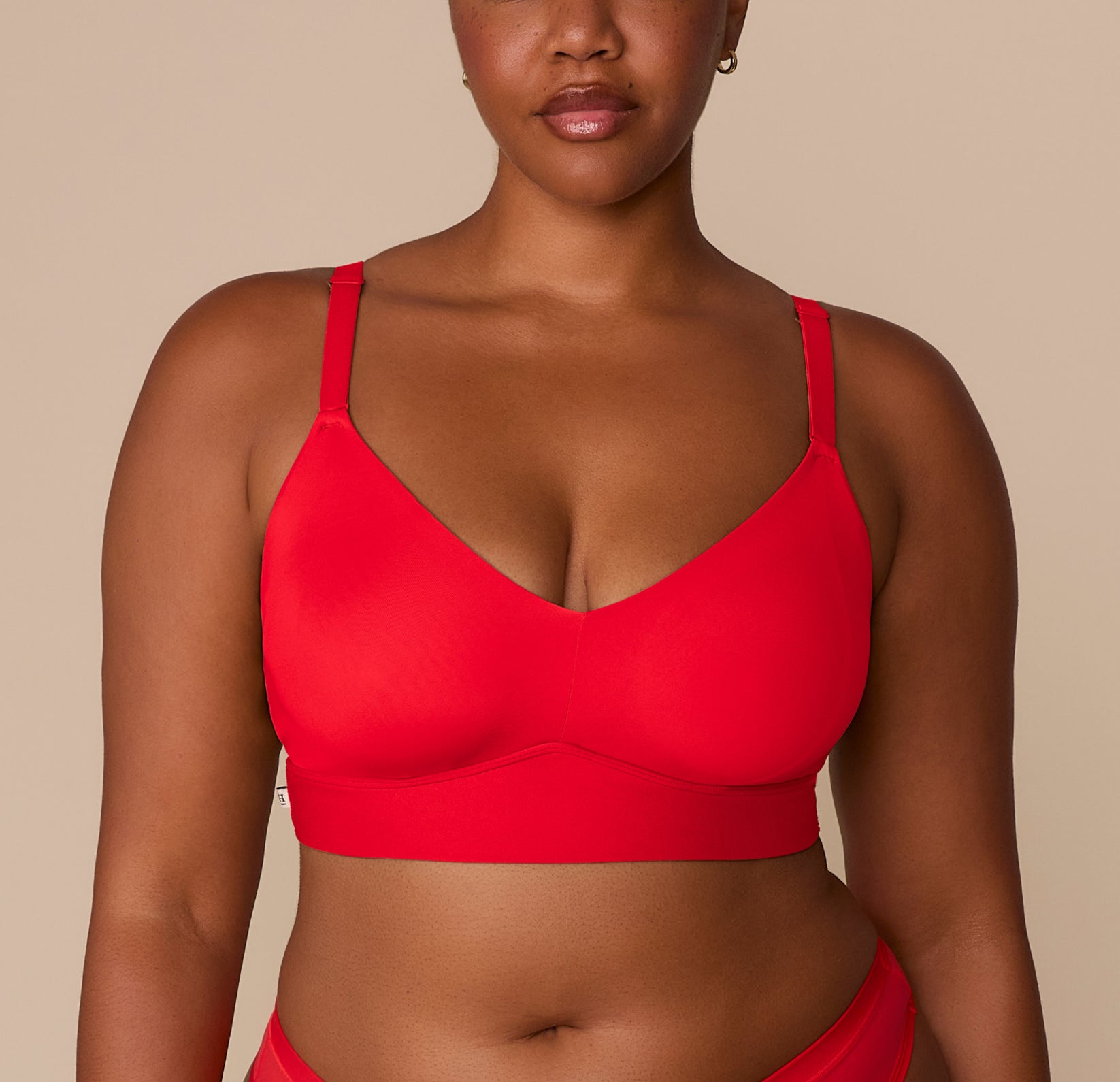 Close-up of Zarria wearing the Bliss Triangle Bralette in Cherry. The image highlights the deep V neckline and ultra-soft microfiber fabric that offers breathable, wireless lift and a barely-there feel. sizing: Zarria wears size 2XL
