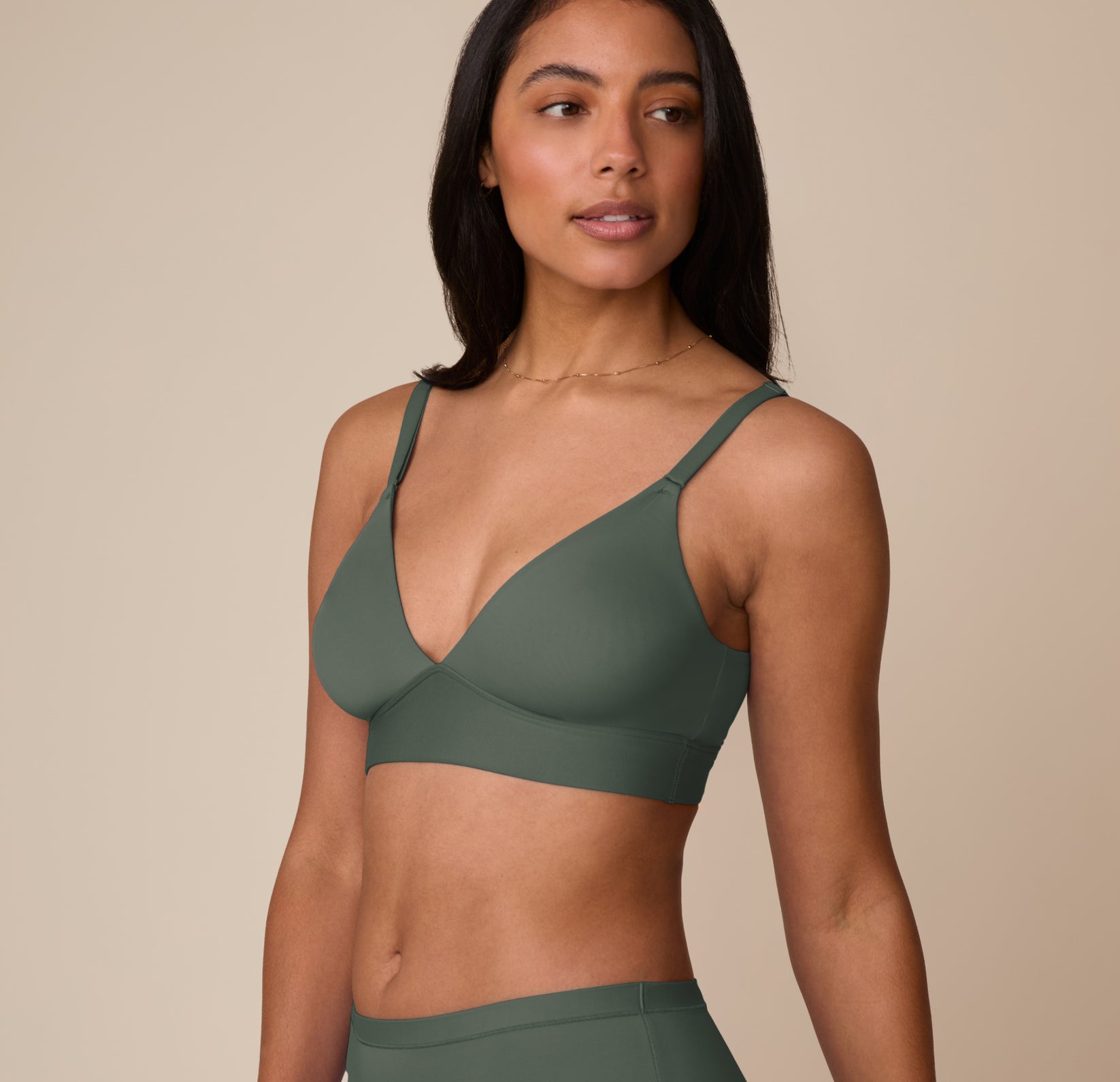 Side angle of Nemesis modeling the Bliss Triangle Bralette in Fir with supportive fit and clean lines.