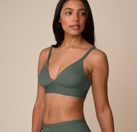 Side angle of Nemesis modeling the Bliss Triangle Bralette in Fir with supportive fit and clean lines.