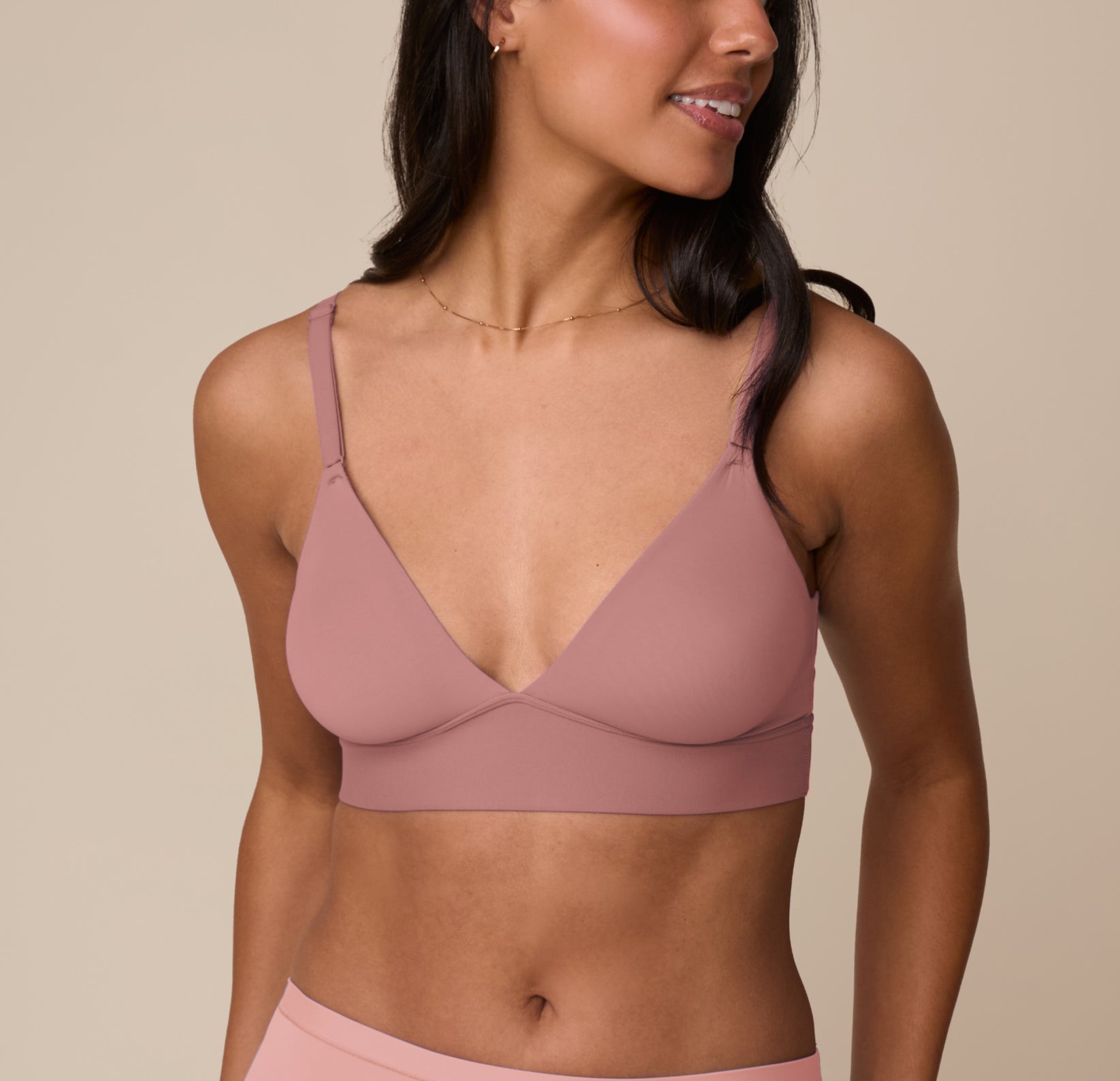 Marcela wearing the Bliss Triangle Bralette in Plum, shown from the front. The bralette features a plunging V-neckline, adjustable straps, and Harper Wilde’s soft microfiber fabric for wireless lift and support. sizing: Marcela wears size Medium