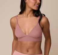 Marcela wearing the Bliss Triangle Bralette in Plum, shown from the front. The bralette features a plunging V-neckline, adjustable straps, and Harper Wilde’s soft microfiber fabric for wireless lift and support. sizing: Marcela wears size Medium
