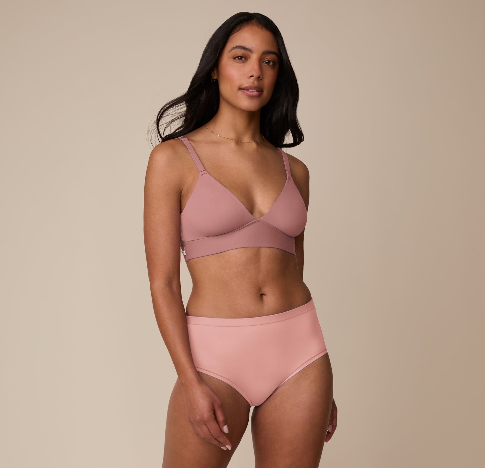 Full body shot of Marcela wearing the Bliss Triangle Bralette in Plum with matching Bliss Highwaist Brief in Dusty Rose. The set emphasizes a supportive, ultra-soft fit designed for everyday comfort.