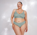Bianca models the Bliss Triangle Bralette in Seaglass, facing forward. The comfortable design and supportive fit offer an elevated everyday style.