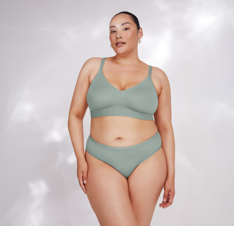 Bianca models the Bliss Triangle Bralette in Seaglass, facing forward. The comfortable design and supportive fit offer an elevated everyday style.