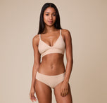 Ally stands wearing the Bliss Triangle Bralette in Beige with the coordinating No-Show Bikini, emphasizing the lightweight, everyday comfort of the bralette.